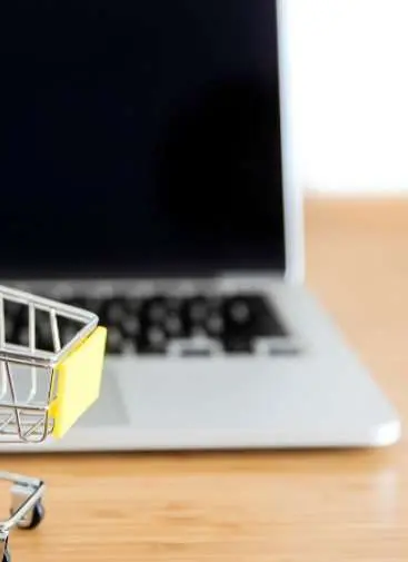 Shopping cart next to a laptop